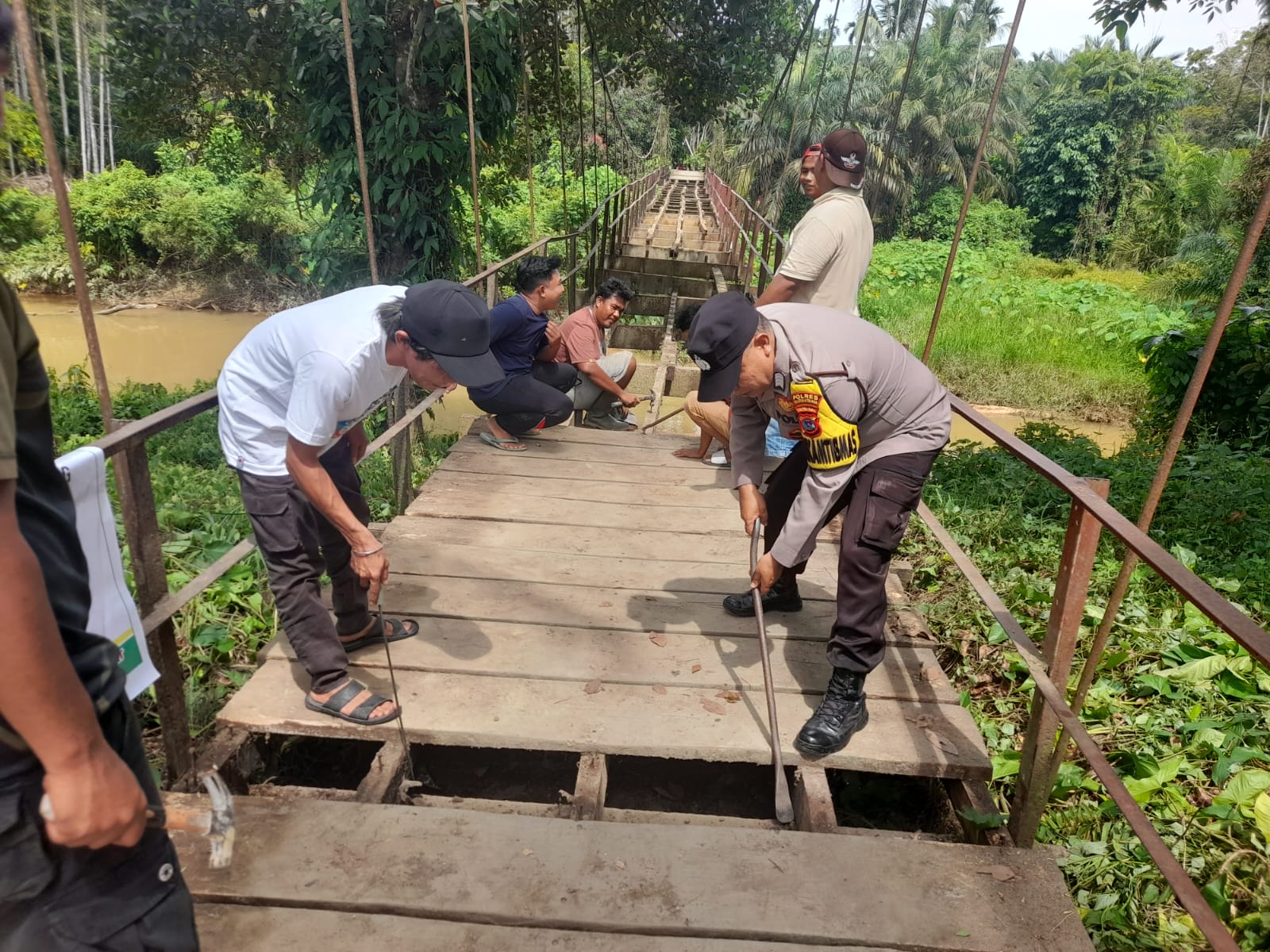 Bhabinkamtibmas Bersama Warga Gotong Royong Pasang Bantalan Jembatan Gantung