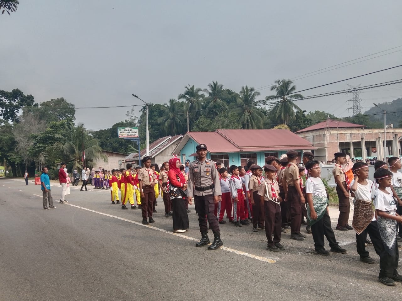 Bhabinkamtibmas Polsek Kamang Baru Pastikan Gerak Jalan Ratusan Siswa SD-SMA Memeriahkan HUT RI ke-81 di Sungai Lansek Berjalan Aman